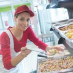 buffet female worker servicing food in cafeteria